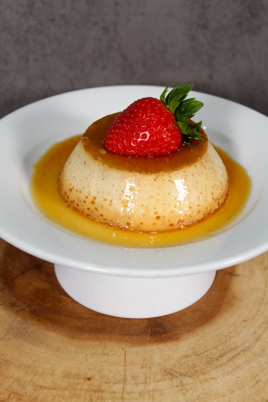 Classic flan dessert topped with fresh strawberry