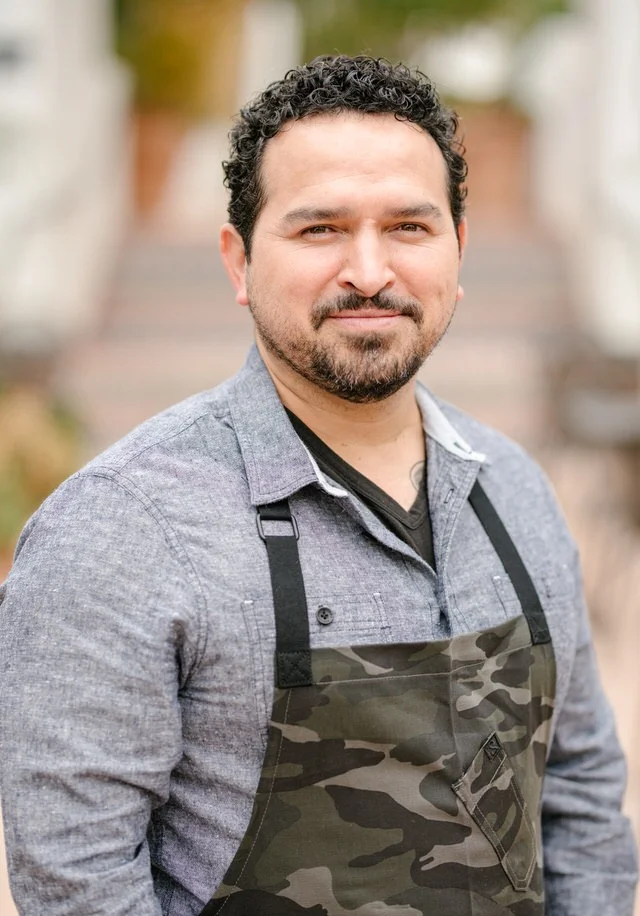 Chef in a camouflage apron smiling outdoors