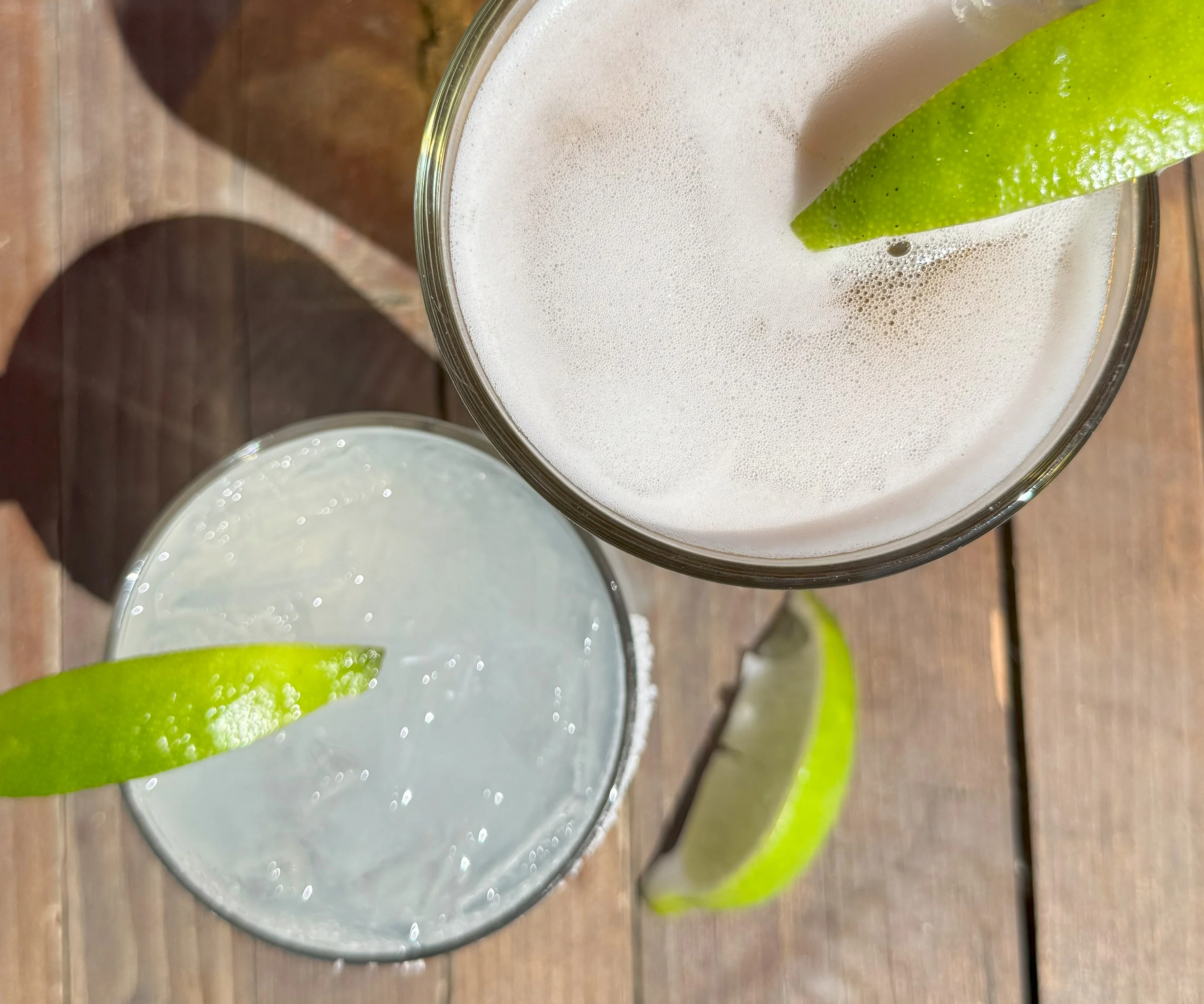 Refreshing cocktails with lime garnishes on a wooden table