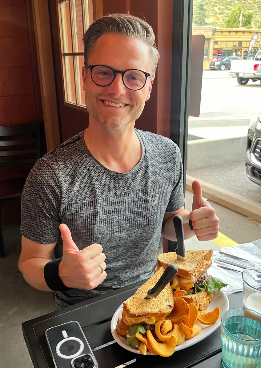Hearty club sandwich with curly fries in a cozy restaurant setting