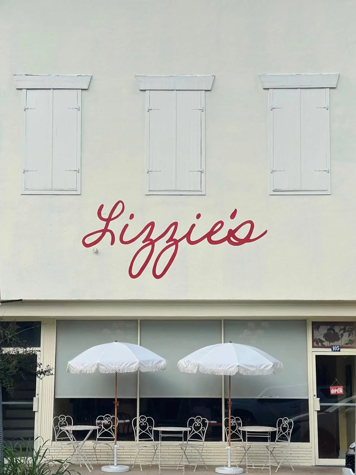 Charming restaurant exterior with white umbrellas and vintage decor