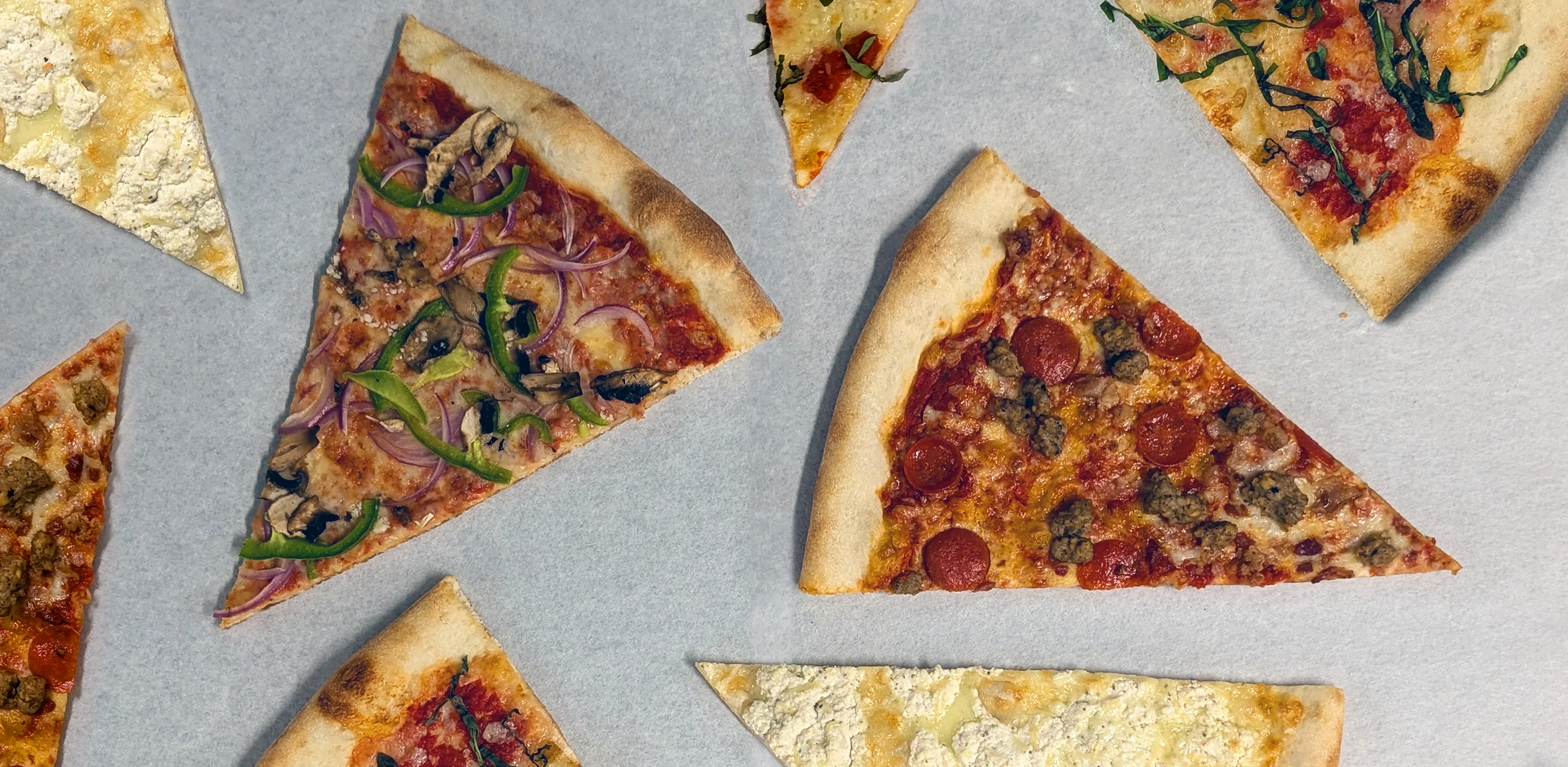 Variety of pizza slices including pepperoni and vegetarian options