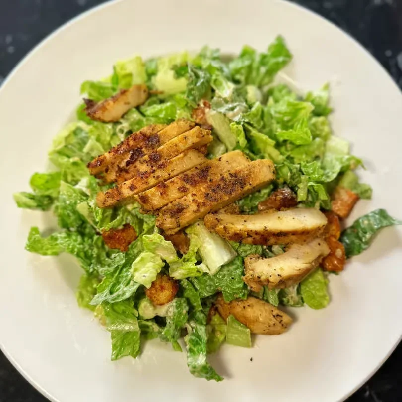 Grilled chicken Caesar salad at Moonlite Diner with crisp romaine lettuce, seasoned chicken, crunchy croutons, and creamy Caesar dressing.