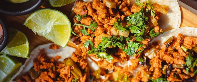 Aztec on Broadway Mexican Restaurant Portland - Al pastor tacos with cilantro and limes on wooden board