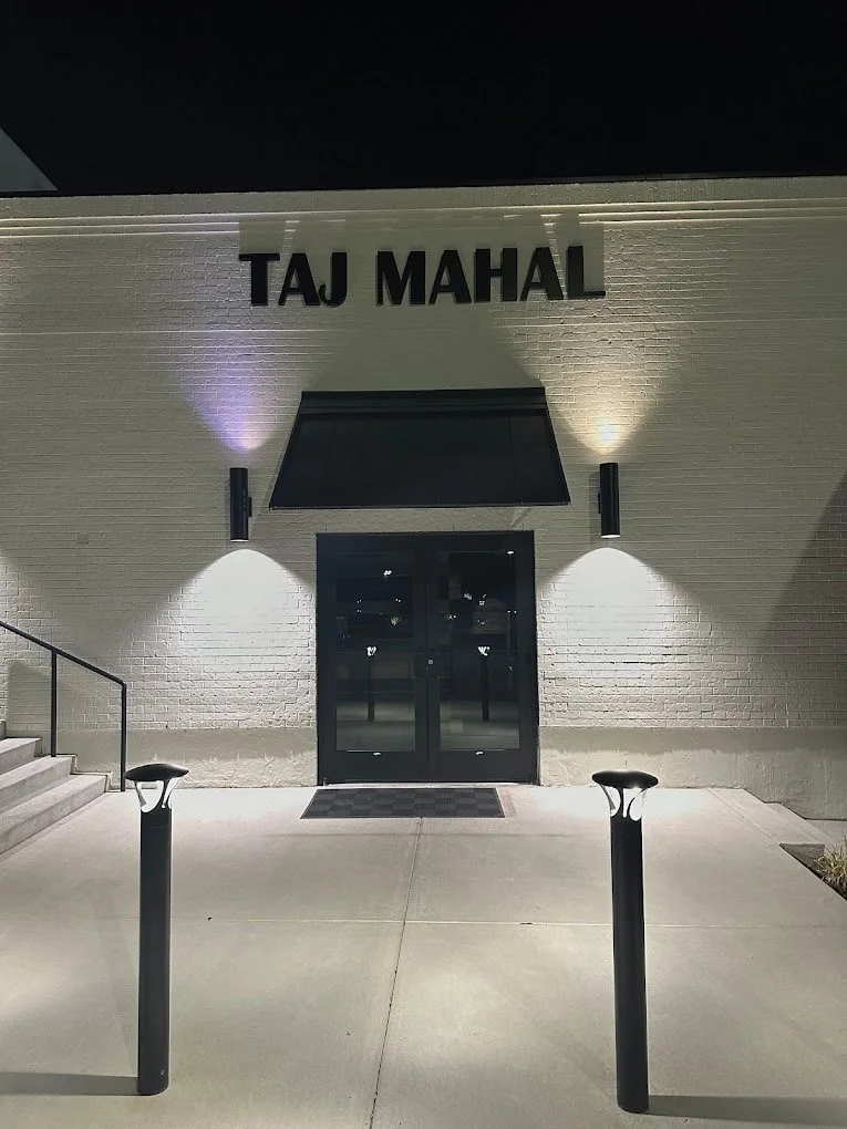 Entrance of Taj Mahal restaurant at night with modern lighting