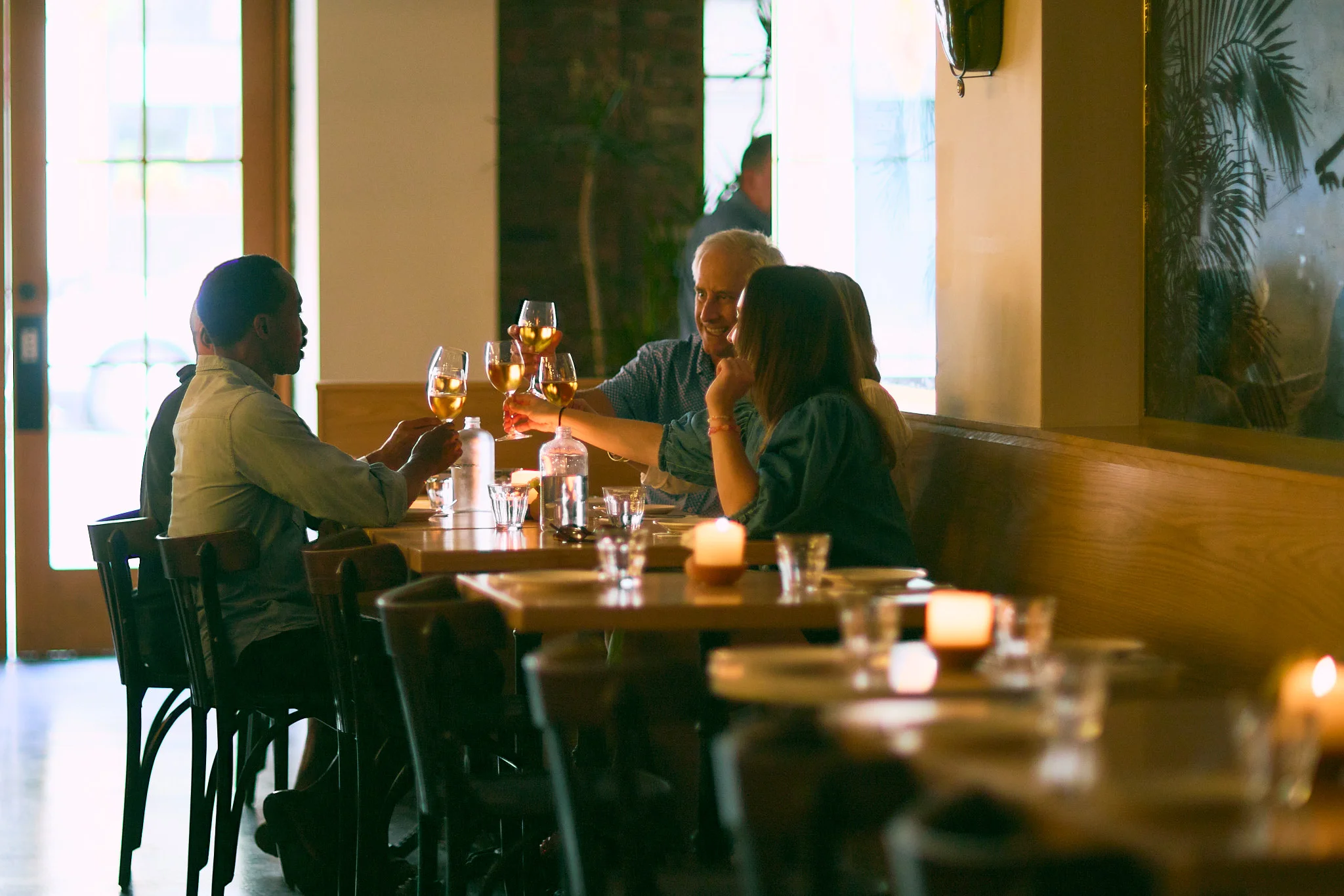 Cozy restaurant interior with friends toasting drinks