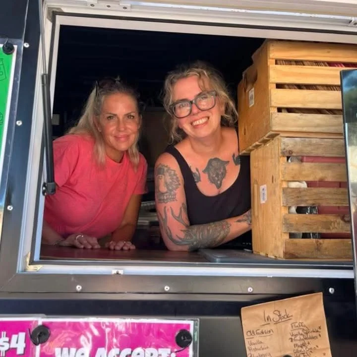 Food truck staff smiling at customers from the window