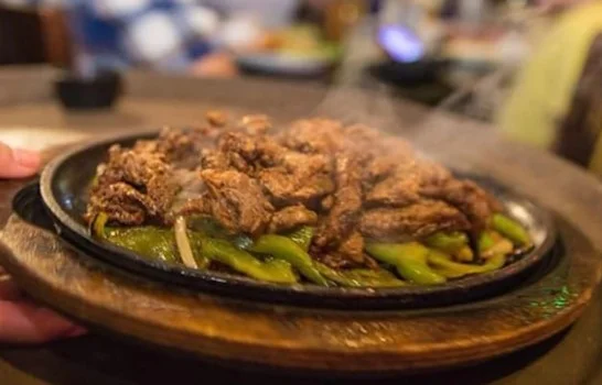 Sizzling fajitas served on a hot skillet