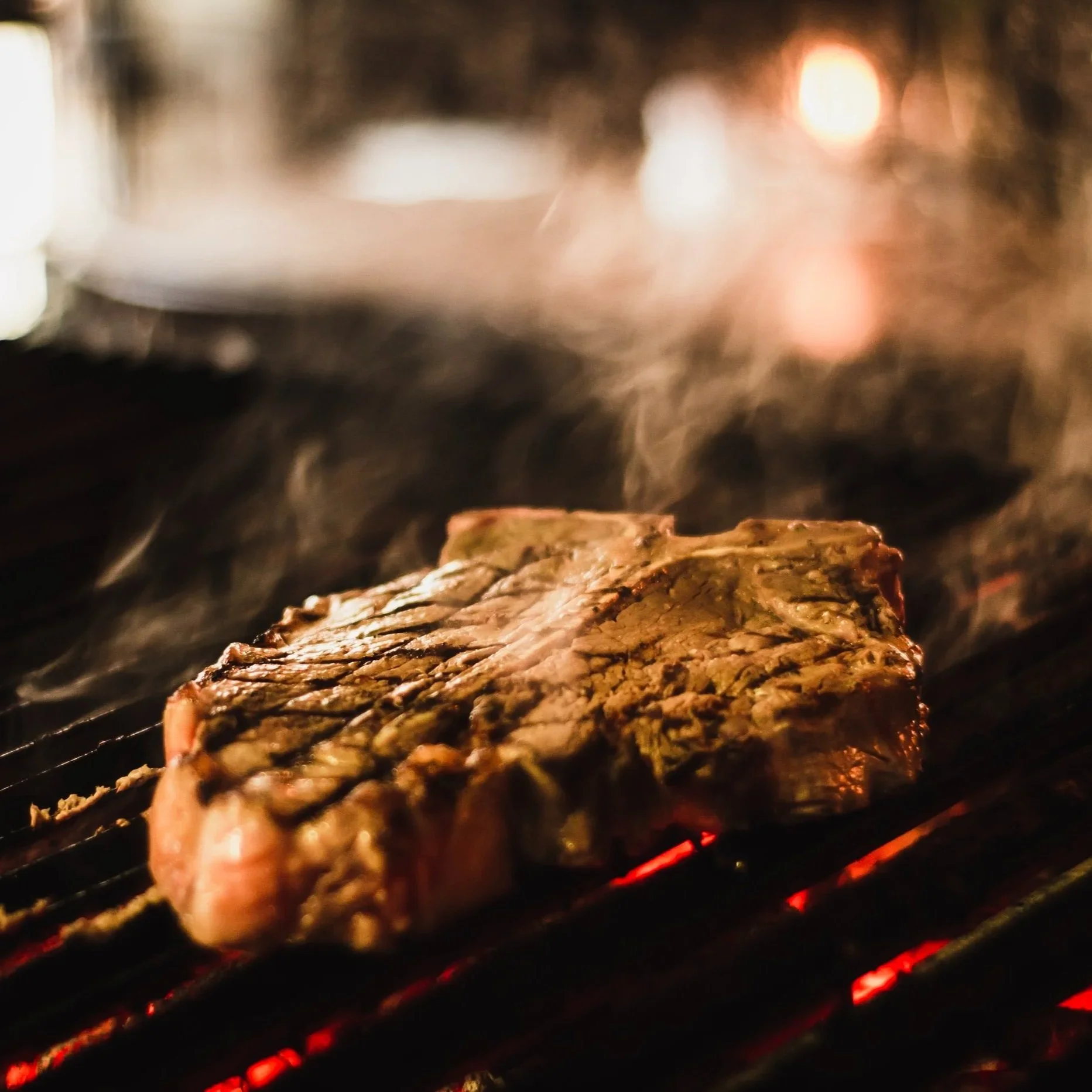 Grilled steak sizzling on a barbecue grill