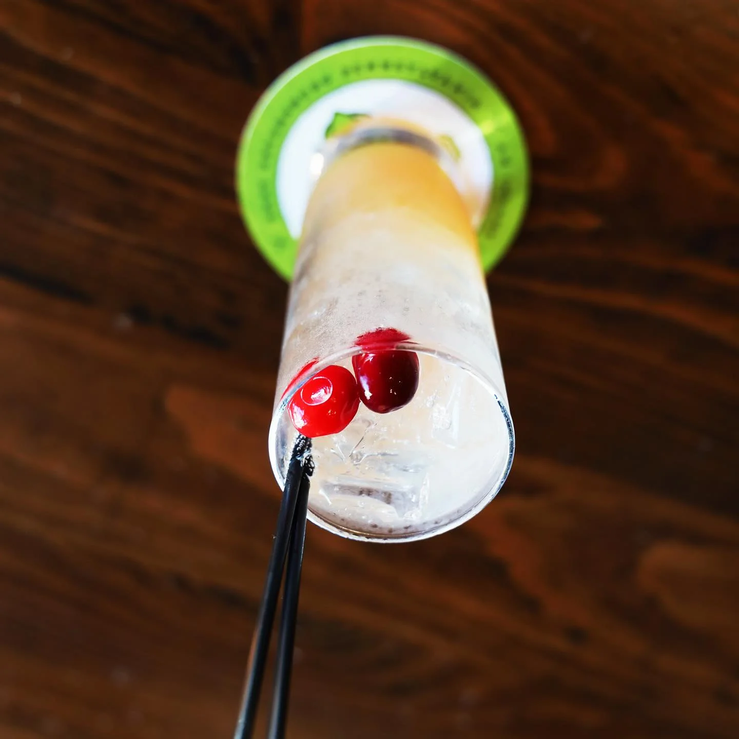 Refreshing cocktail with cherries and ice in a tall glass