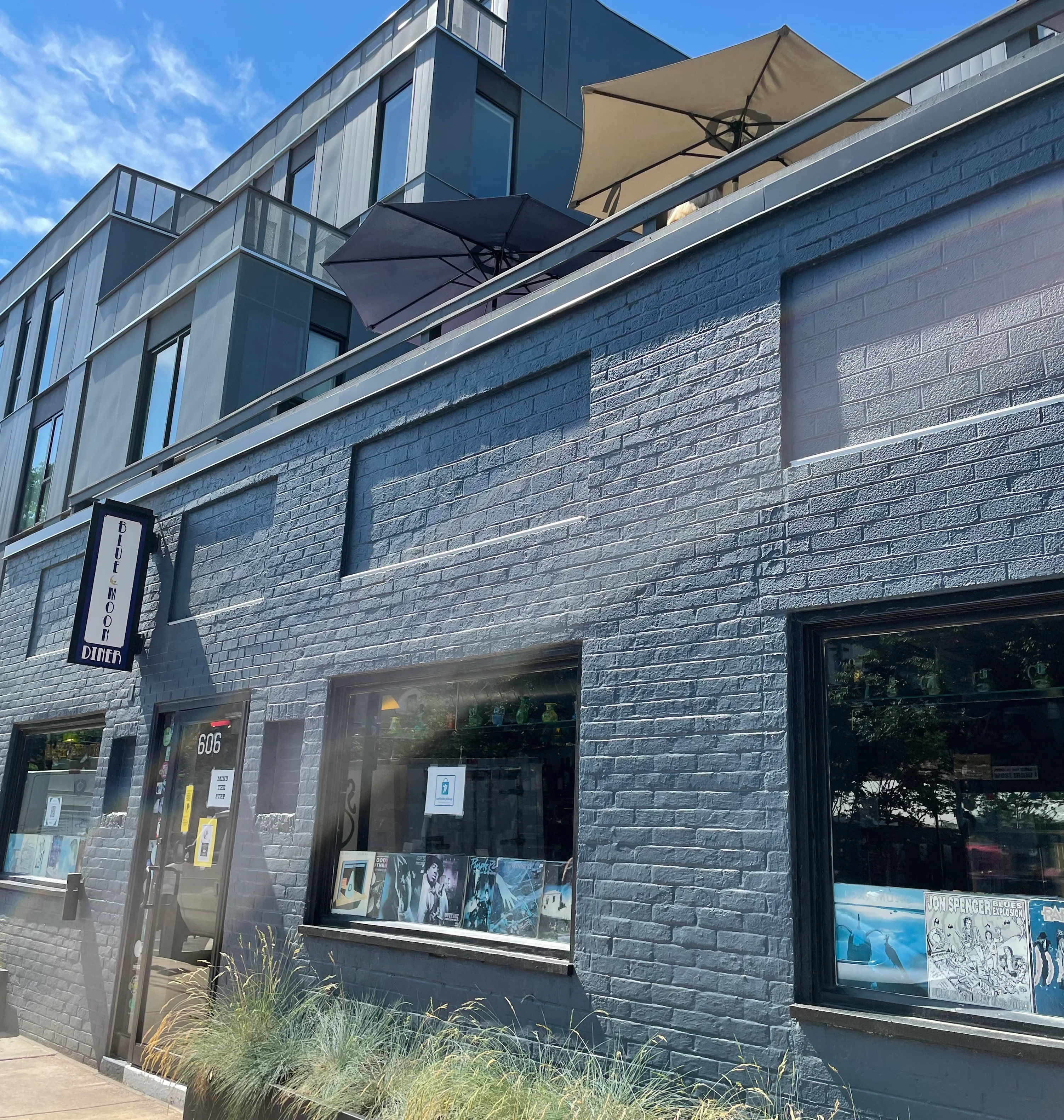 Exterior view of Blue Moon Diner with modern architecture and patio umbrellas