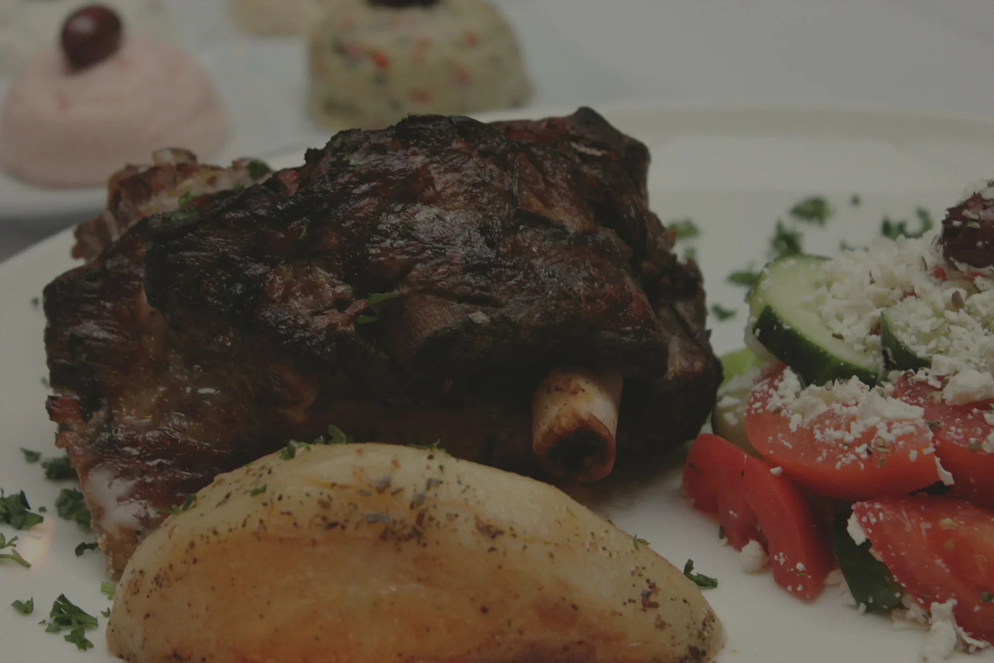 Grilled lamb shank with Mediterranean salad and baked potato