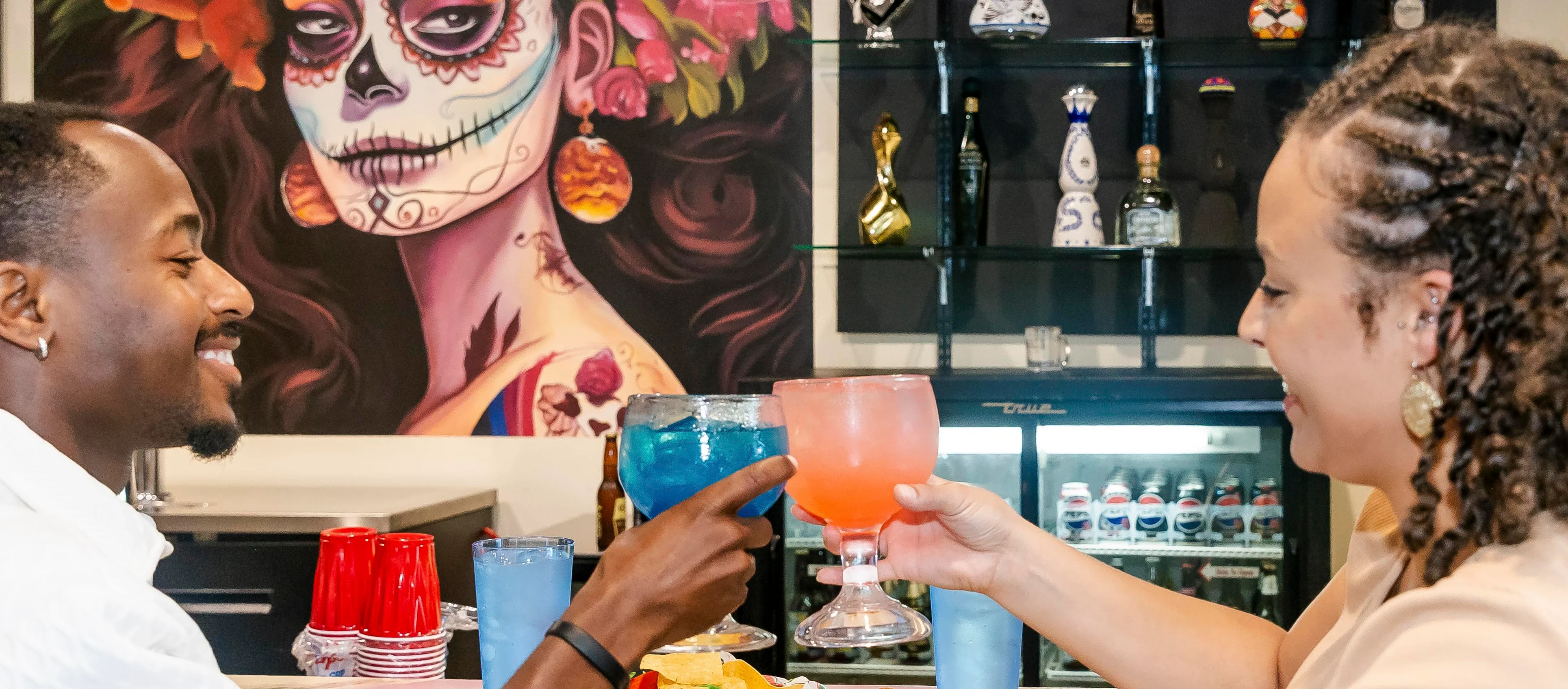Couple toasting cocktails at a vibrant Mexican restaurant