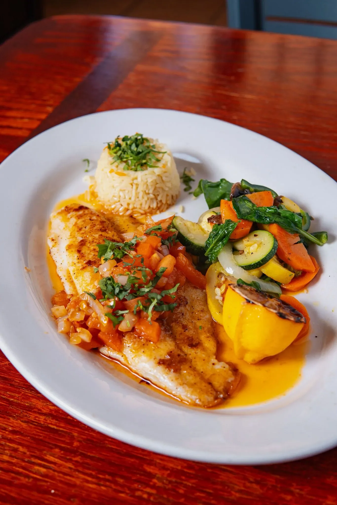 Grilled fish with fresh salsa and vegetables, served with rice