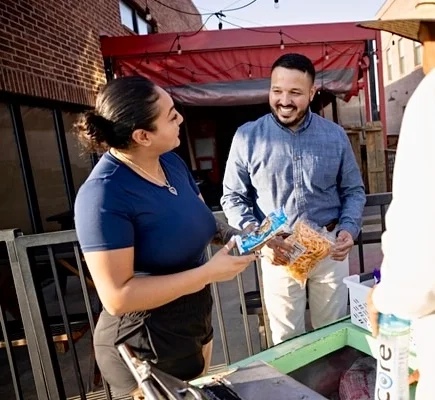 Friendly interaction at a food stall with customers and staff