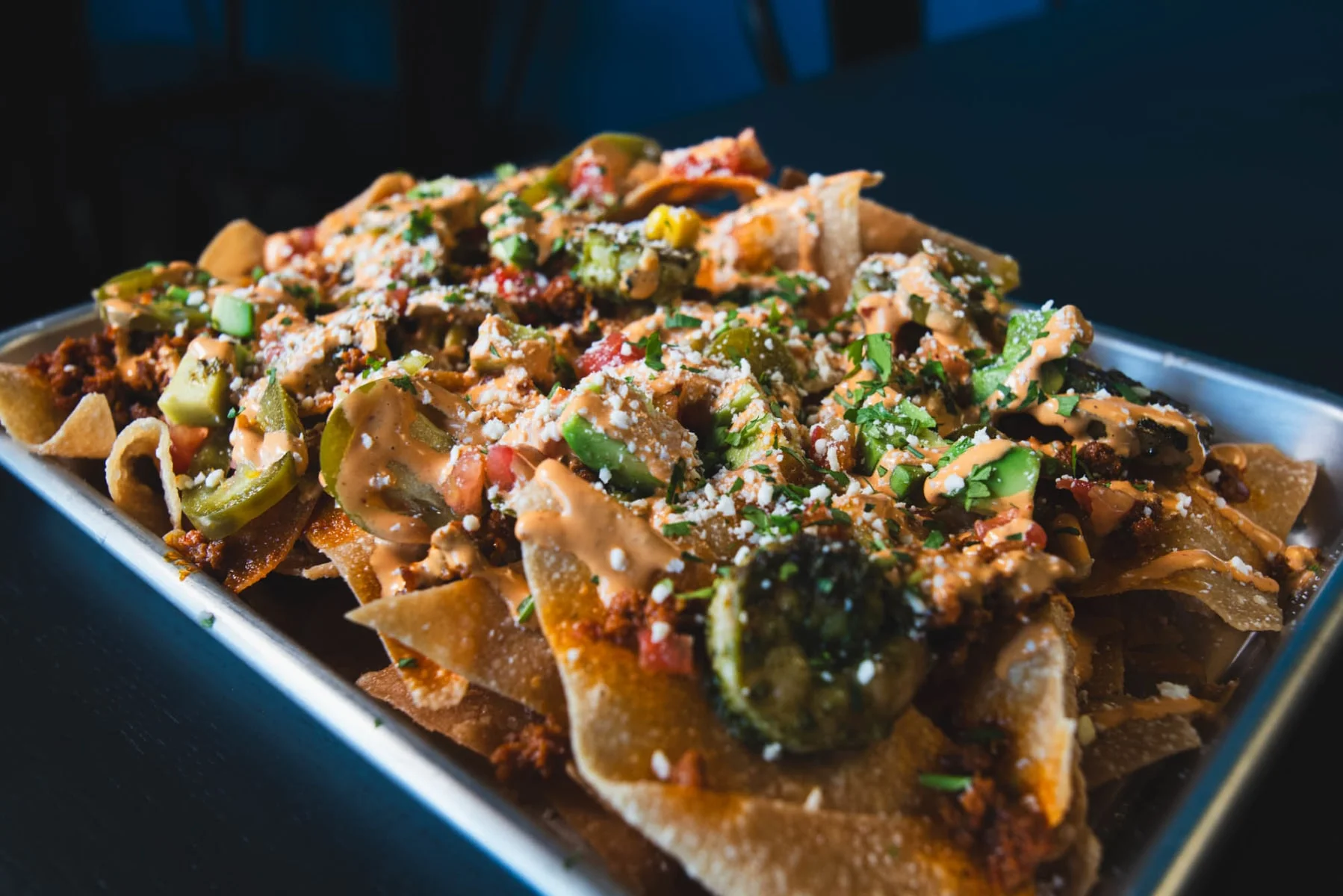 Loaded nachos topped with cheese and jalapeños