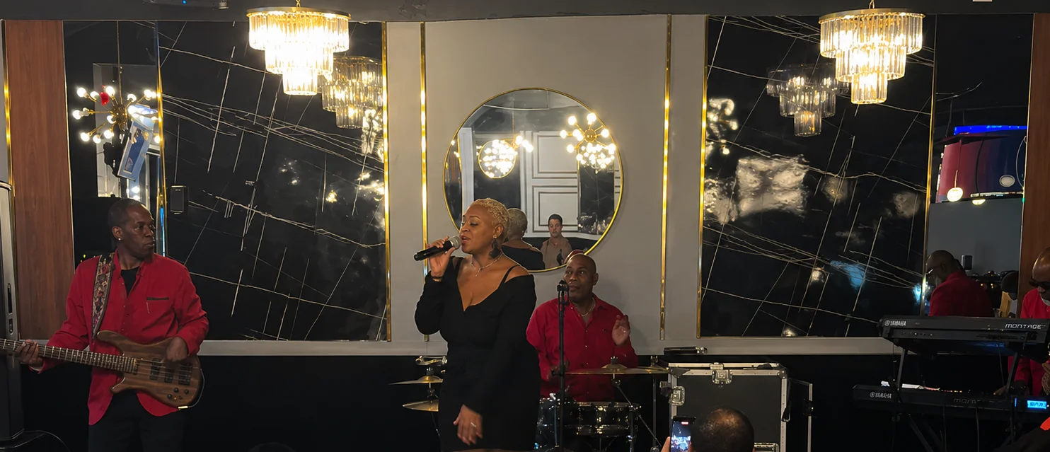 Live music performance at a restaurant with a singer and band members.