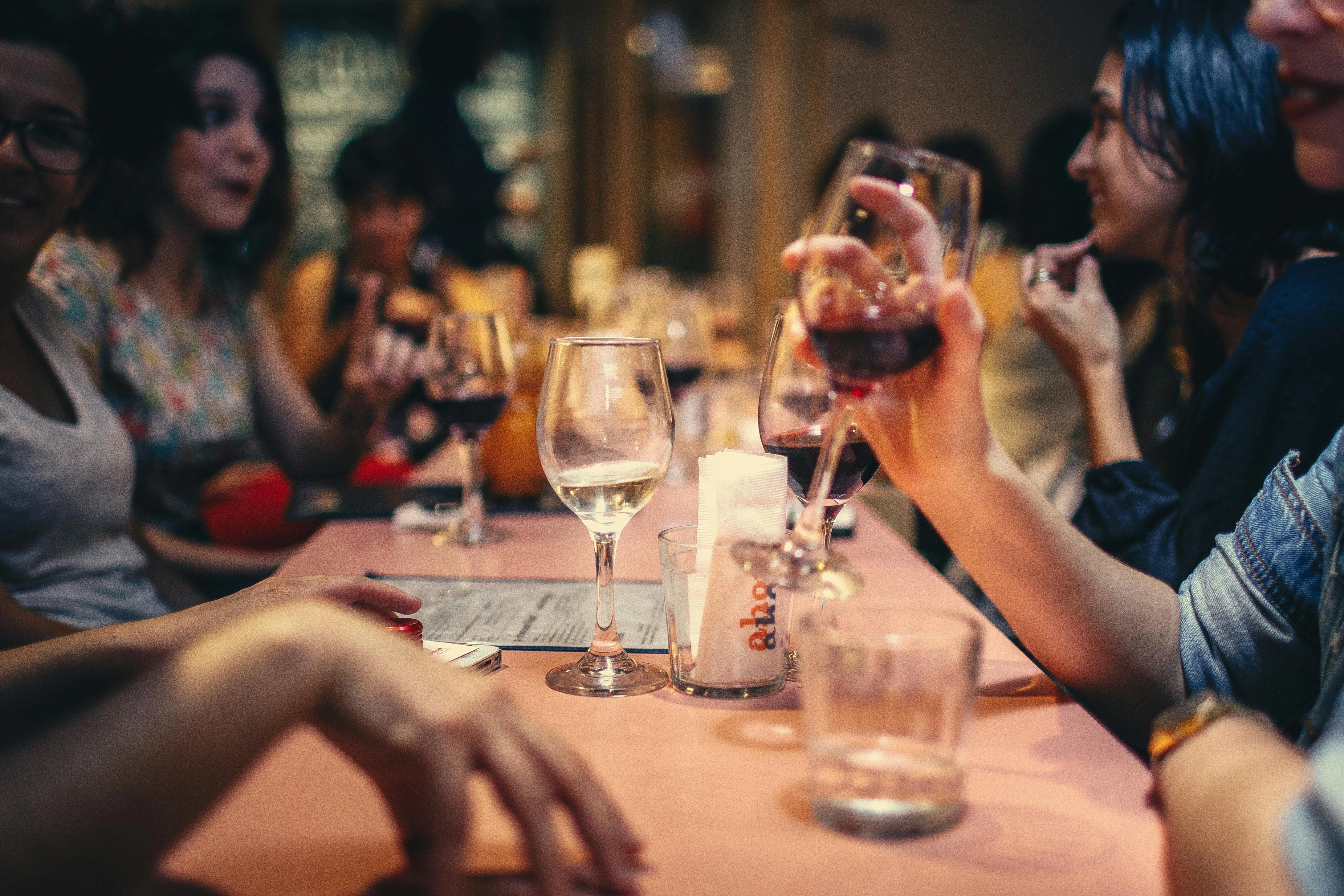 Group of friends enjoying drinks at a lively restaurant table