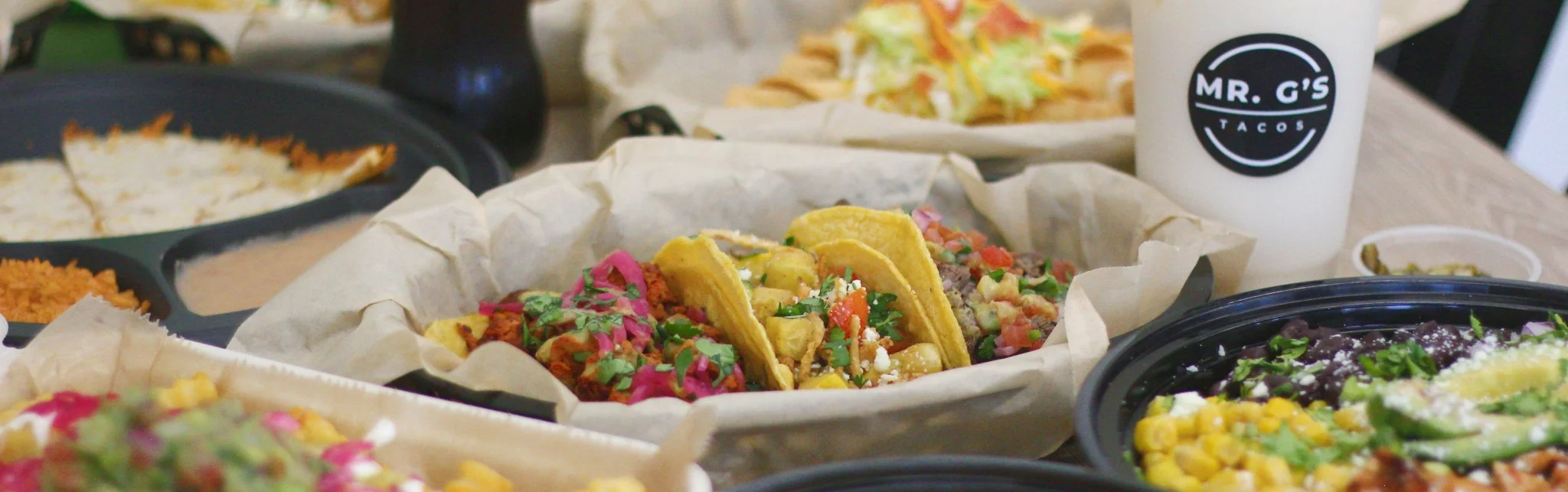 Mexican street tacos served with colorful toppings and Mexican side dishes