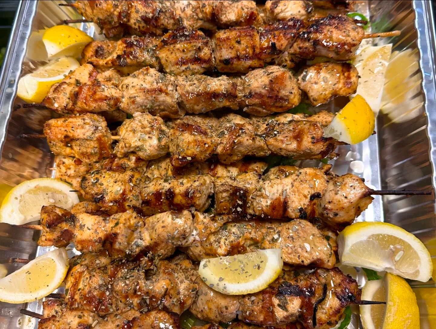 Grilled chicken kebabs with lemon wedges
