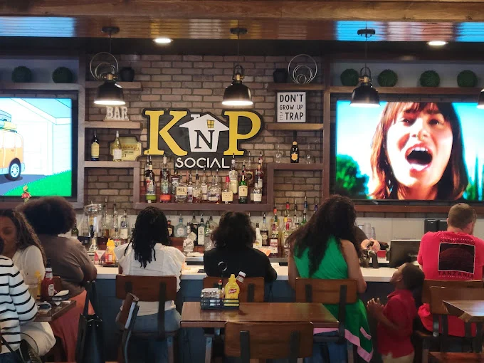 Interior of a restaurant with seating, arcade games, and a TV.