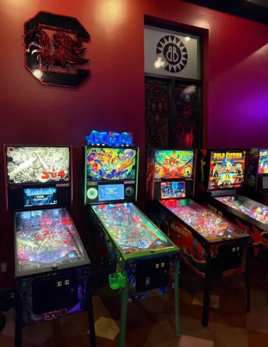 Arcade pinball machines in a colorful restaurant game room