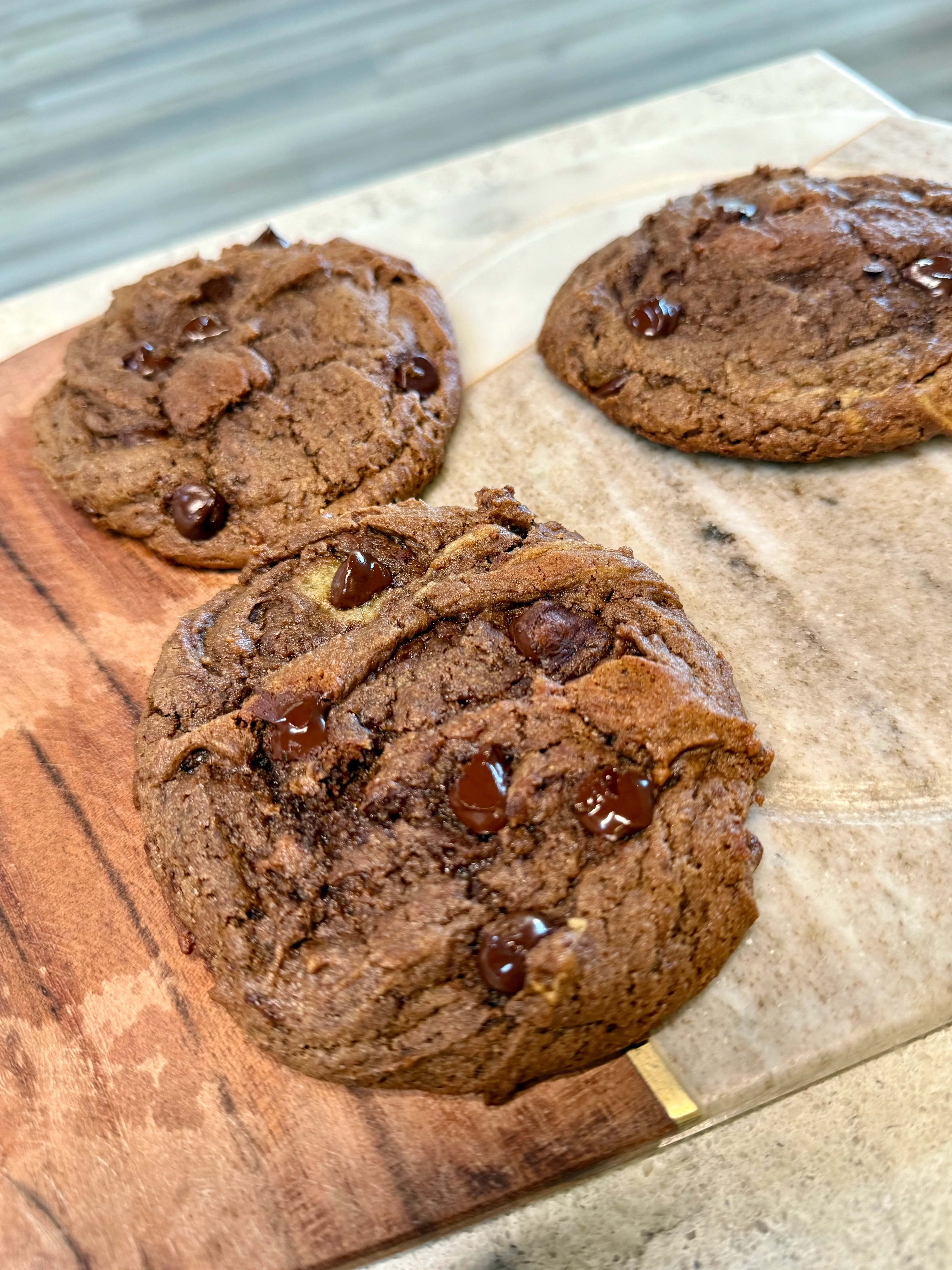 Freshly baked chocolate chip cookies on a wooden board
