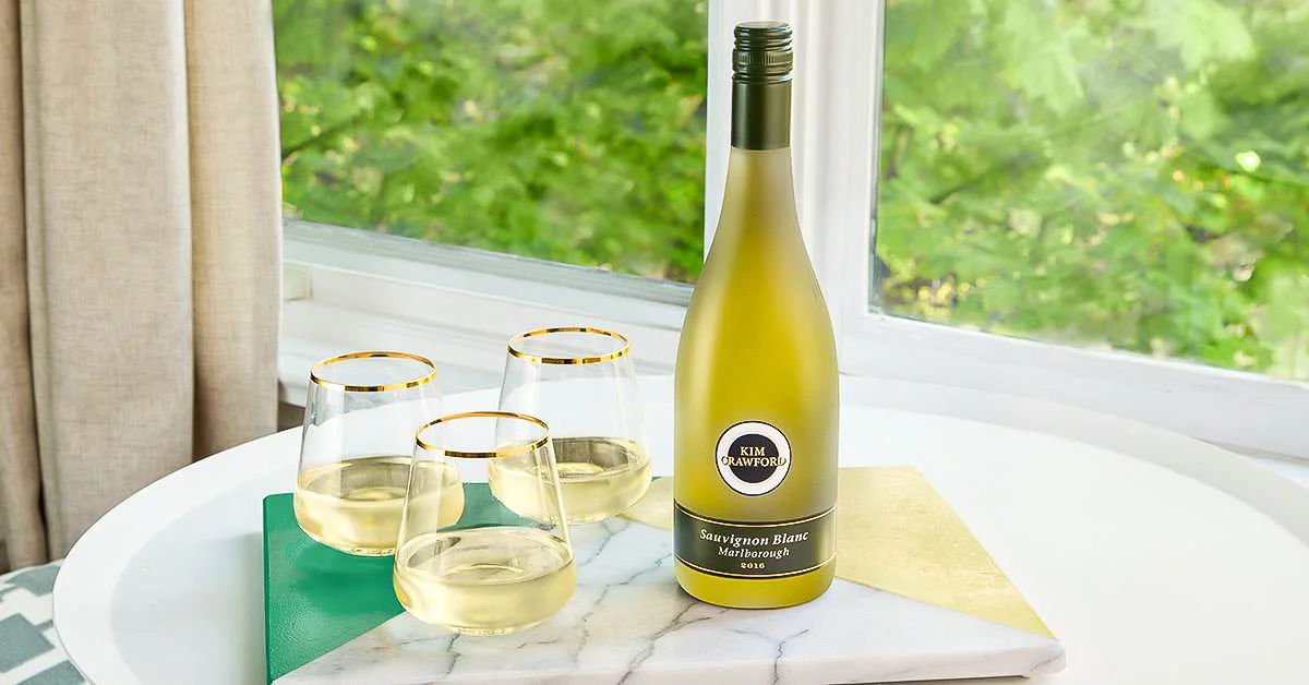Bottle of Sauvignon Blanc with glasses on a table by the window