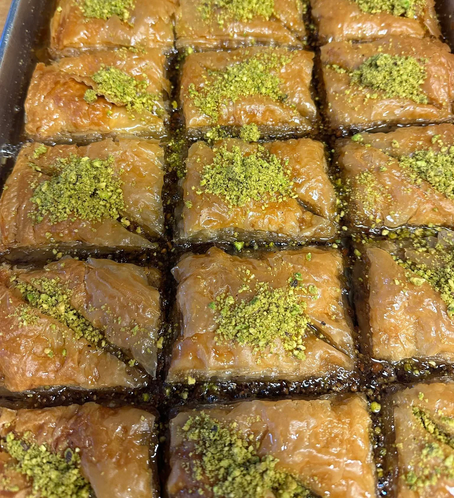 Delicious baklava drizzled with syrup and topped with pistachios