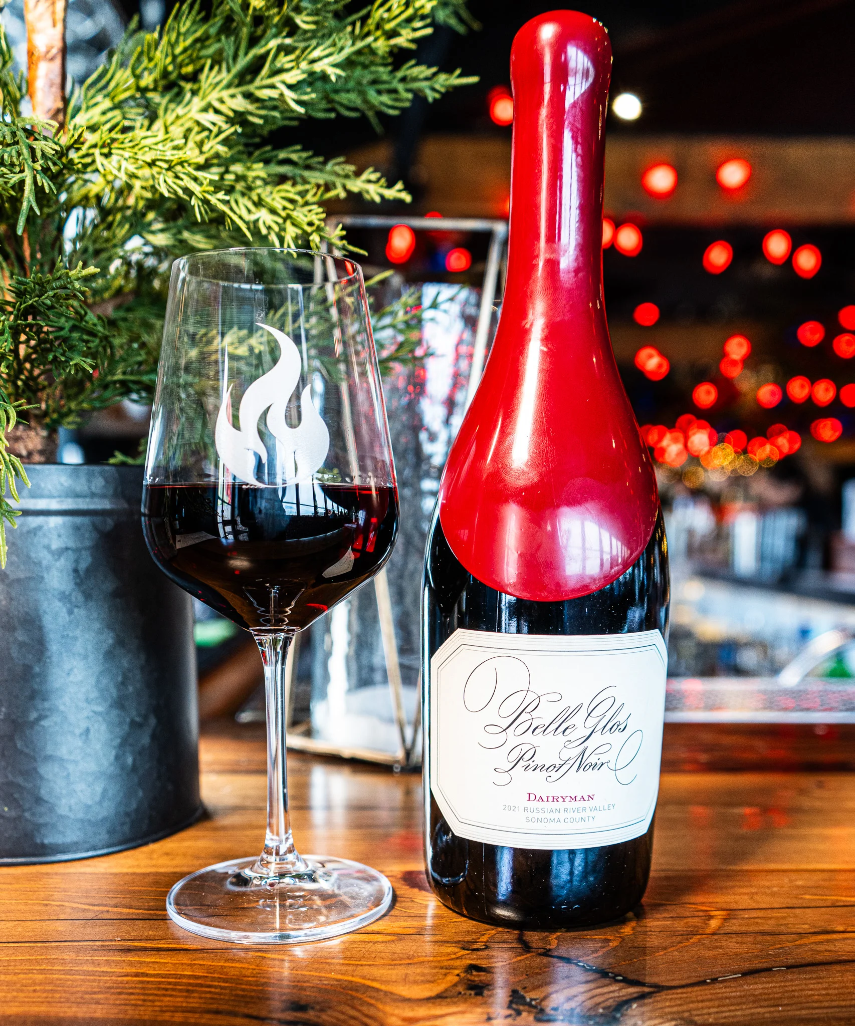 Bottle of Belle Glos Pinot Noir with a glass in a cozy restaurant setting