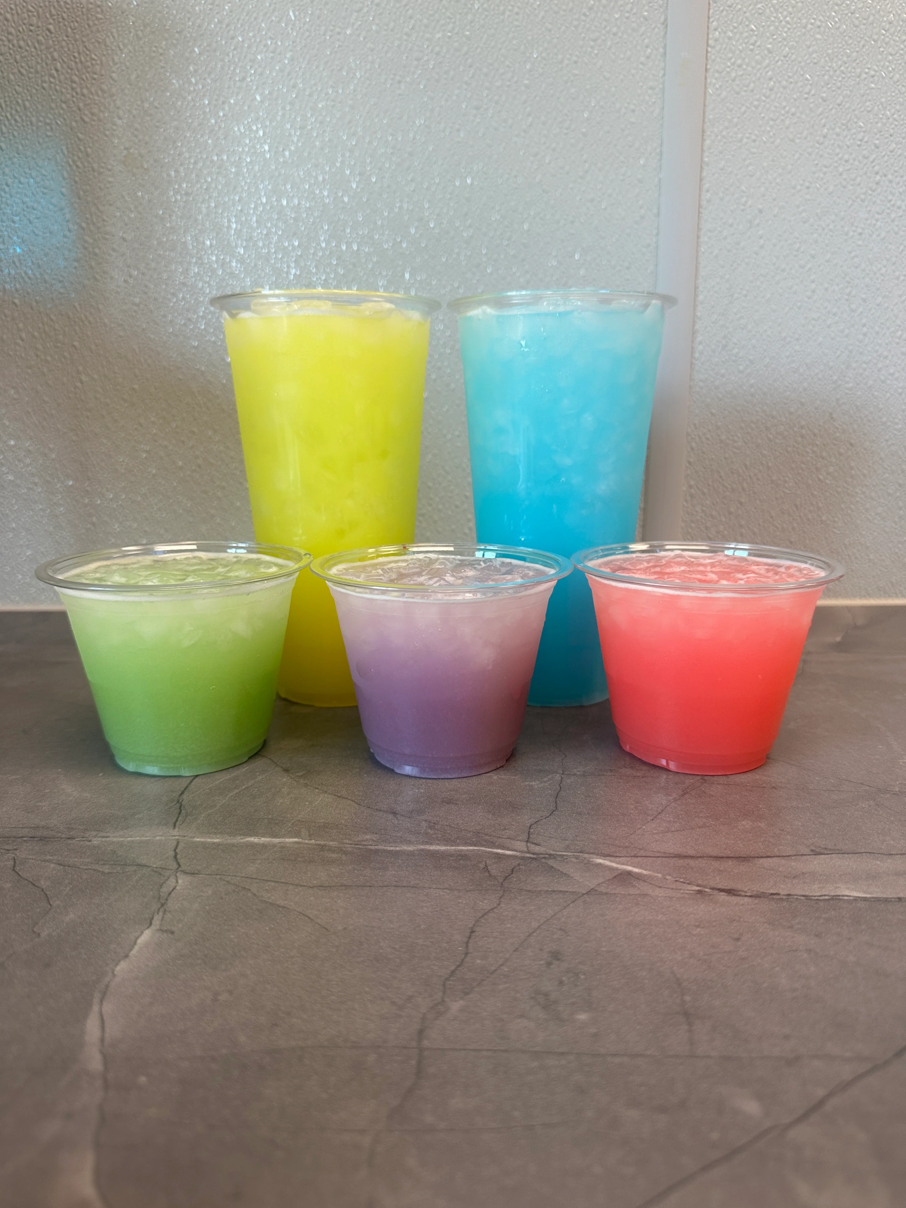 Colorful assortment of refreshing summer drinks in plastic cups