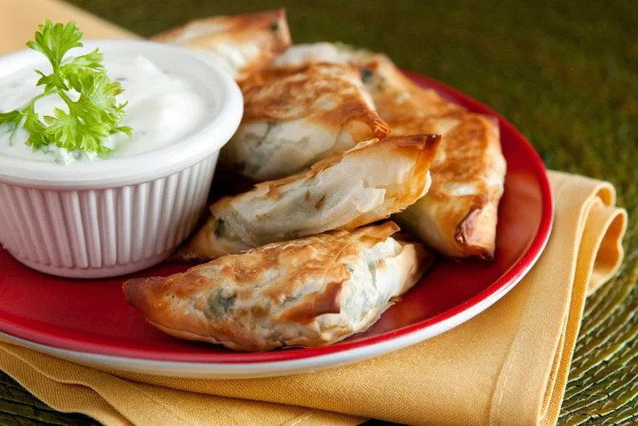 Delicious appetizer platter with various dips and garnishes.