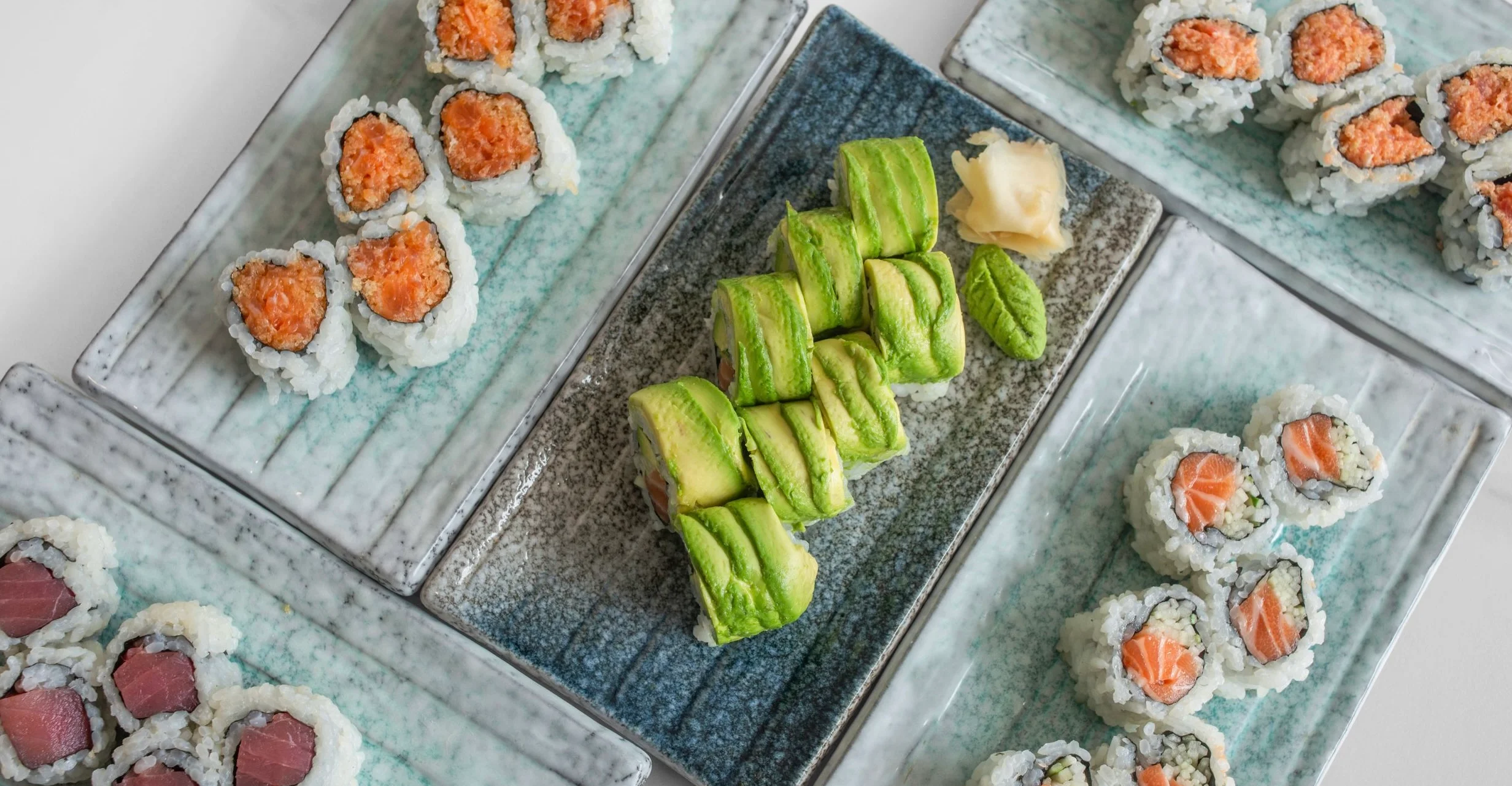 Assorted sushi rolls on elegant plates, showcasing Japanese cuisine