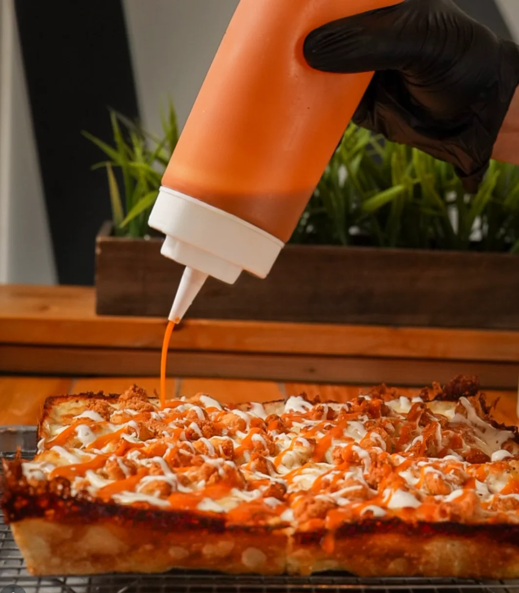Buffalo chicken pizza drizzled with sauce