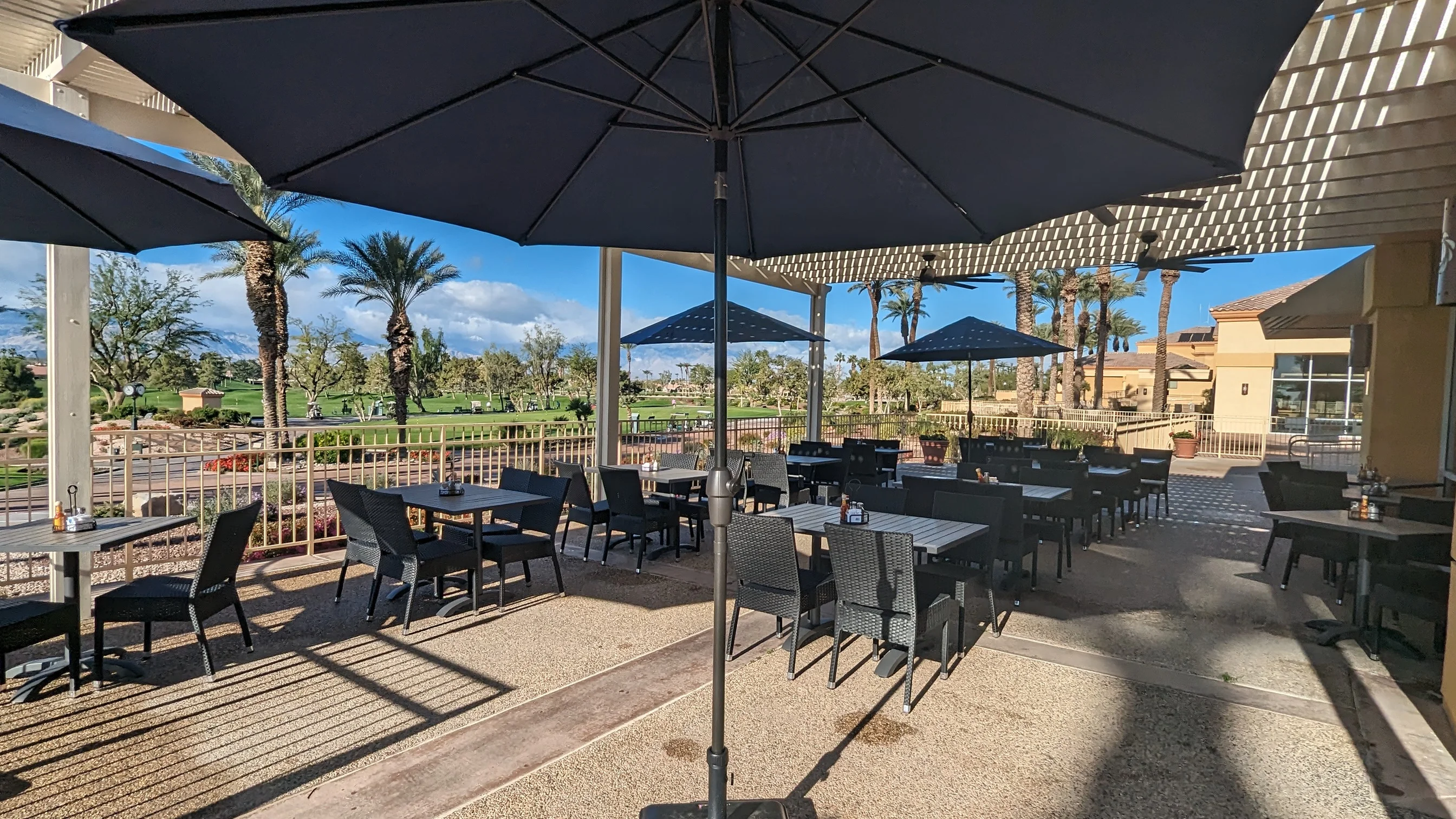 Outdoor dining area with umbrellas and palm trees