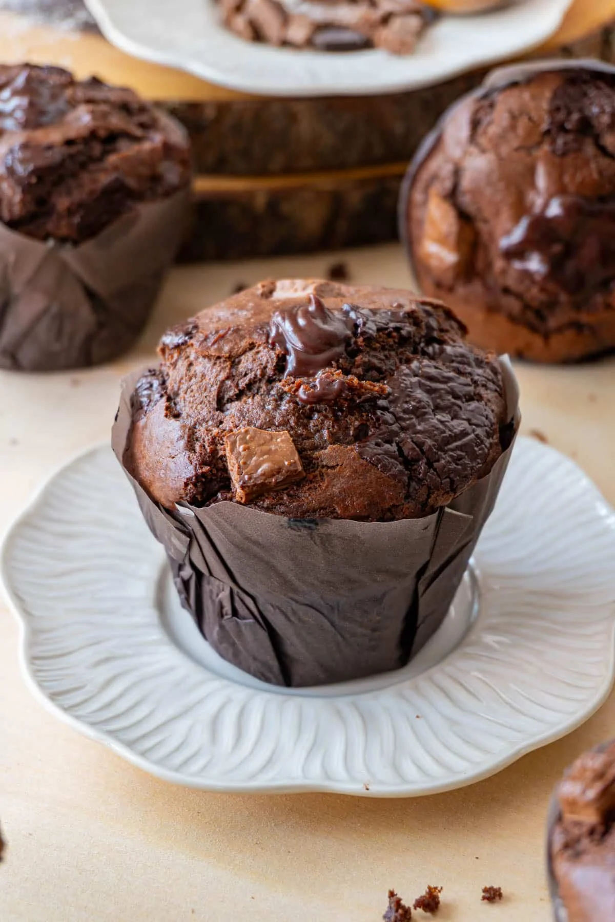Delicious chocolate muffin with chocolate chunks on a decorative plate.