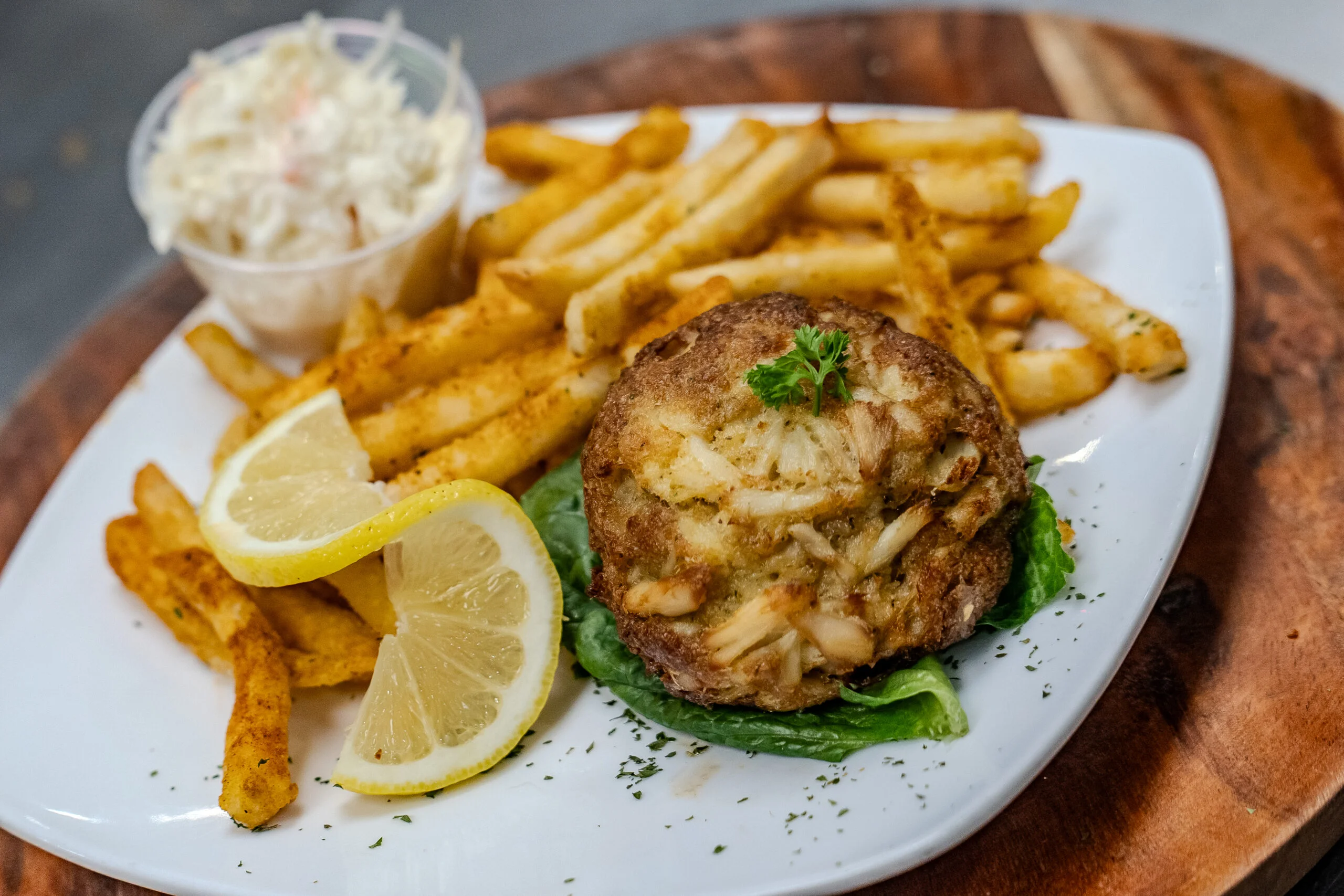 Delicious crab cake platter with fries and coleslaw