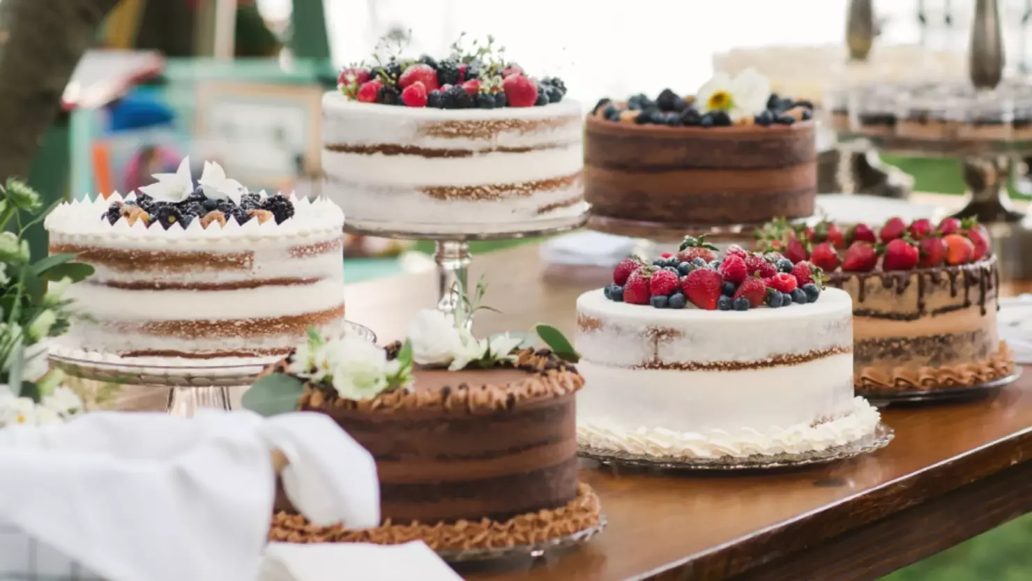 Assorted elegant cakes with fresh berries and floral decorations