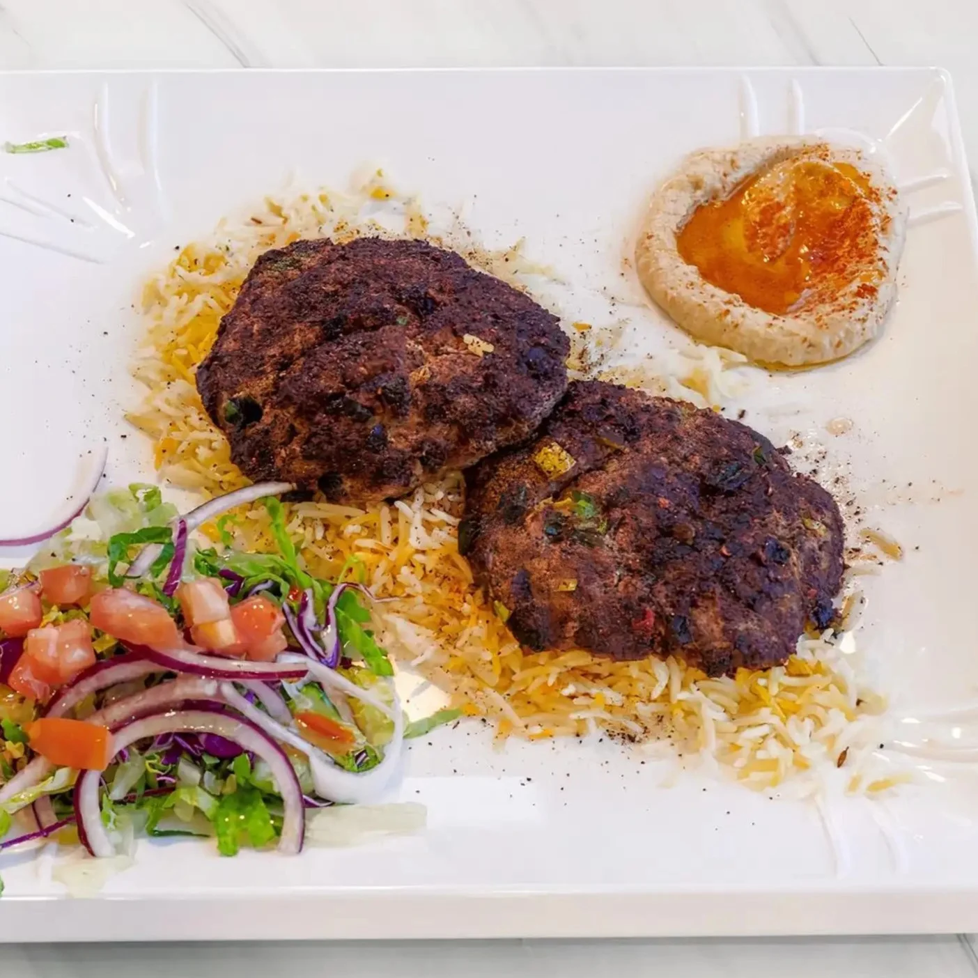Spiced kebab patties served with rice and hummus
