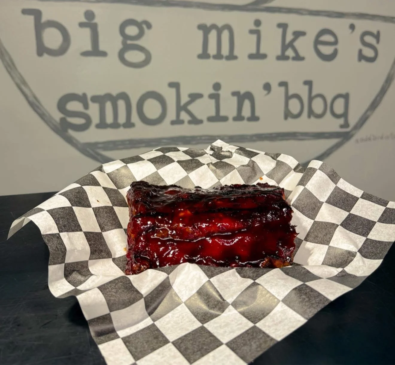 Delicious BBQ ribs on a checkered paper at Big Mike's Smokin' BBQ.