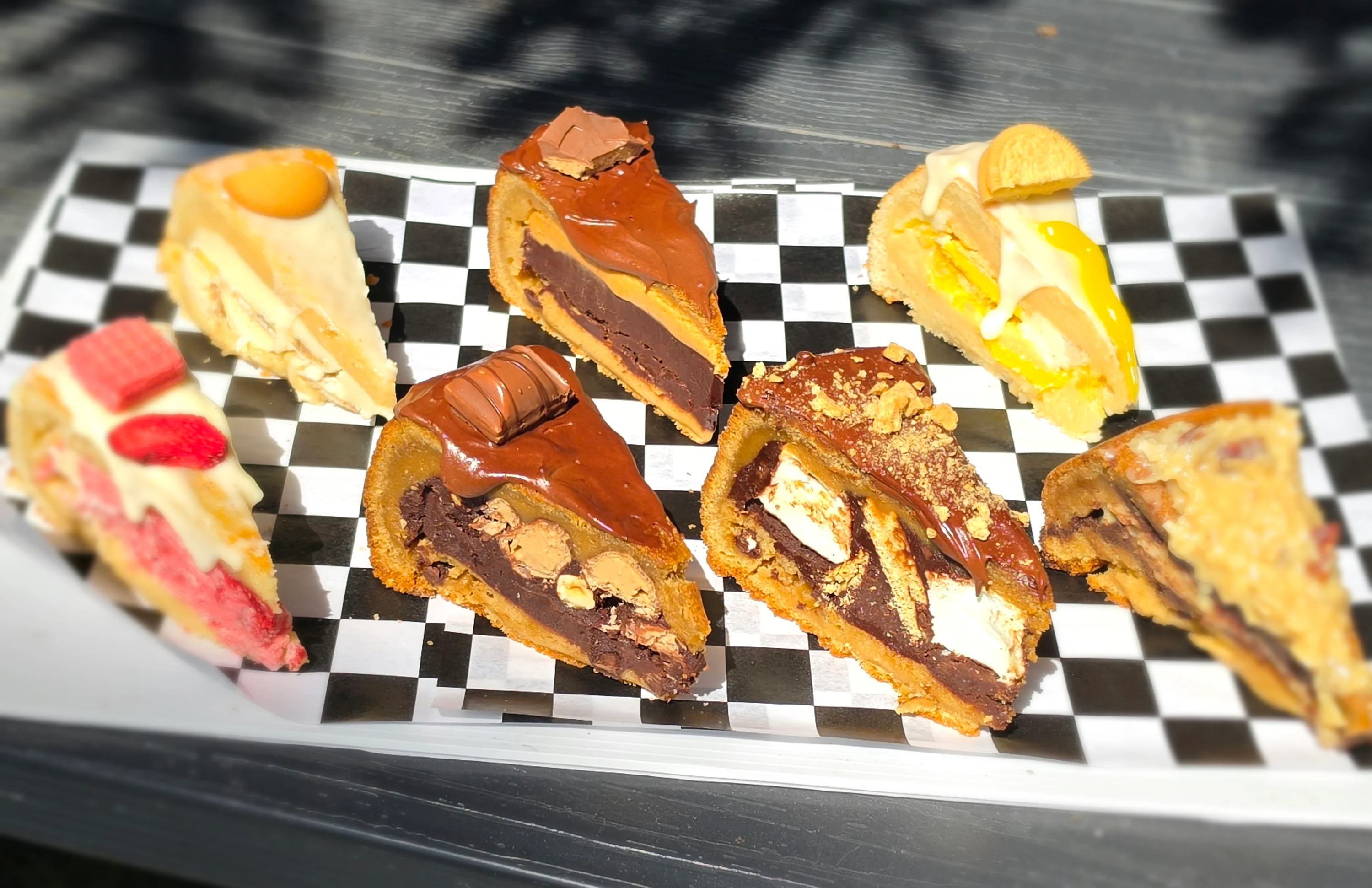 Assorted gourmet cheesecake slices on a checkered platter