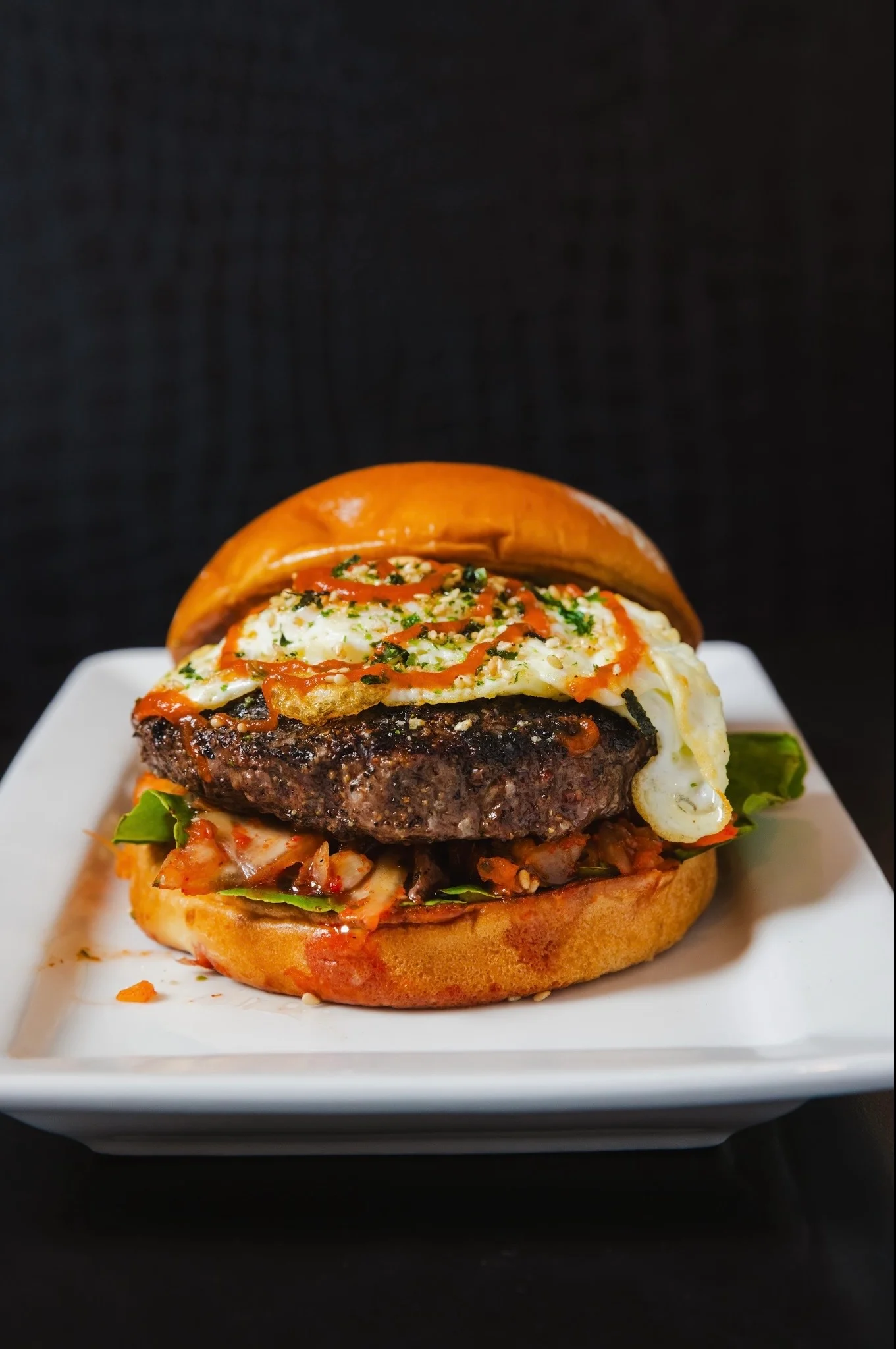 Juicy burger with fried egg and spicy sauce