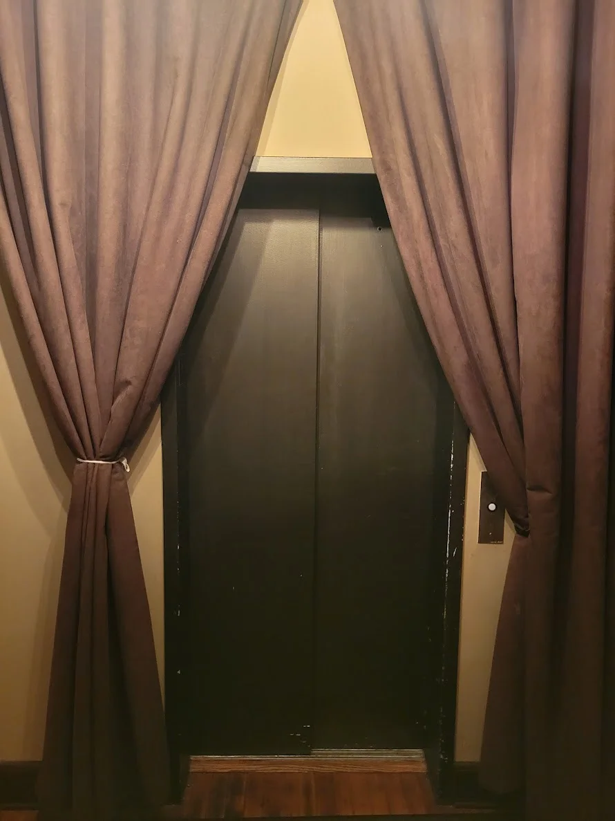 Brown curtains framing a closed door in a cozy setting.