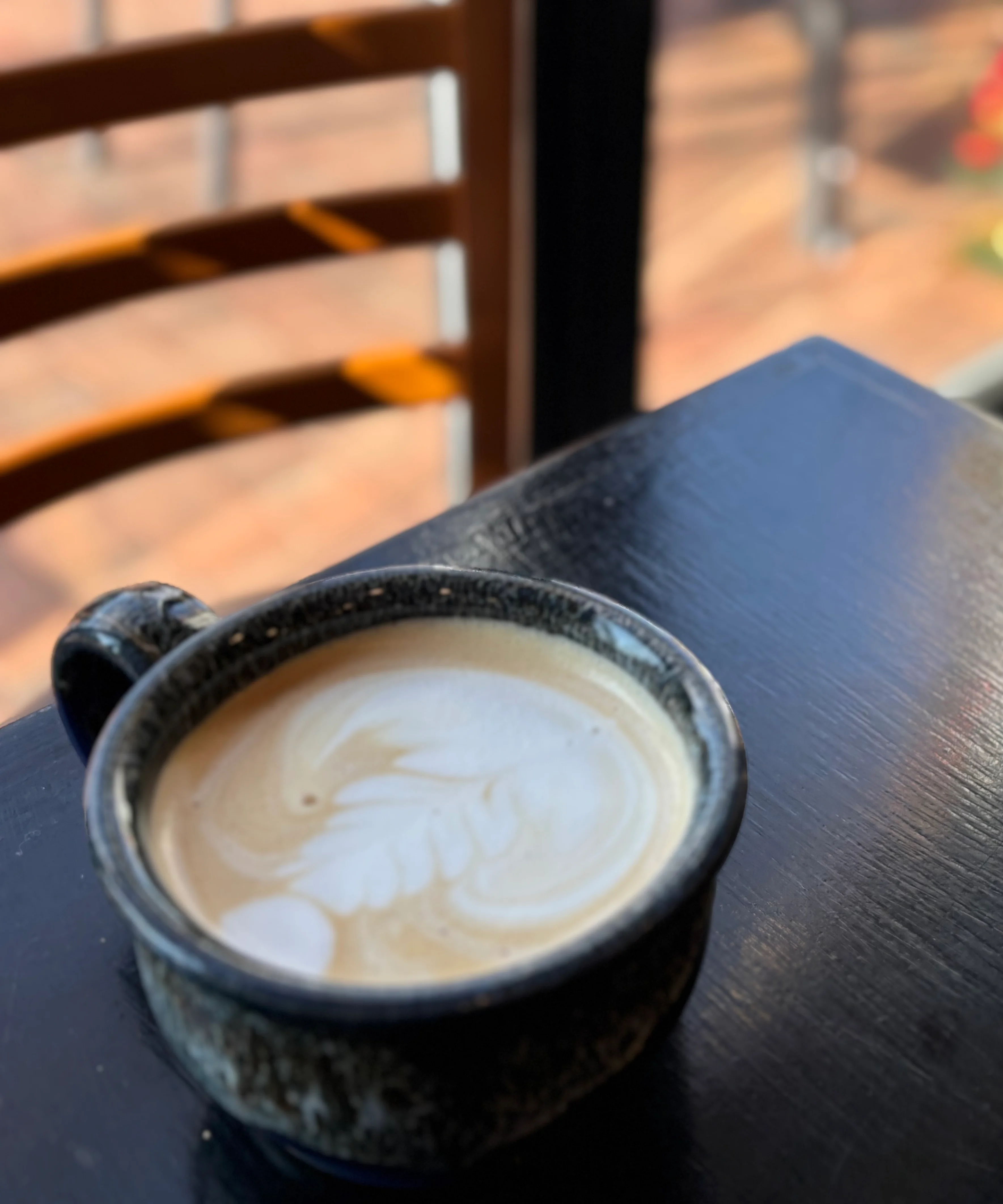 Artisan latte with intricate foam art in a cozy café setting
