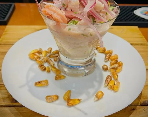 Peruvian ceviche served in a glass with onions and herbs
