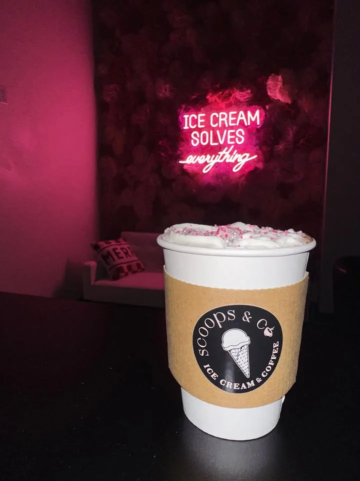 Coffee cup with whipped cream in a cozy ice cream shop