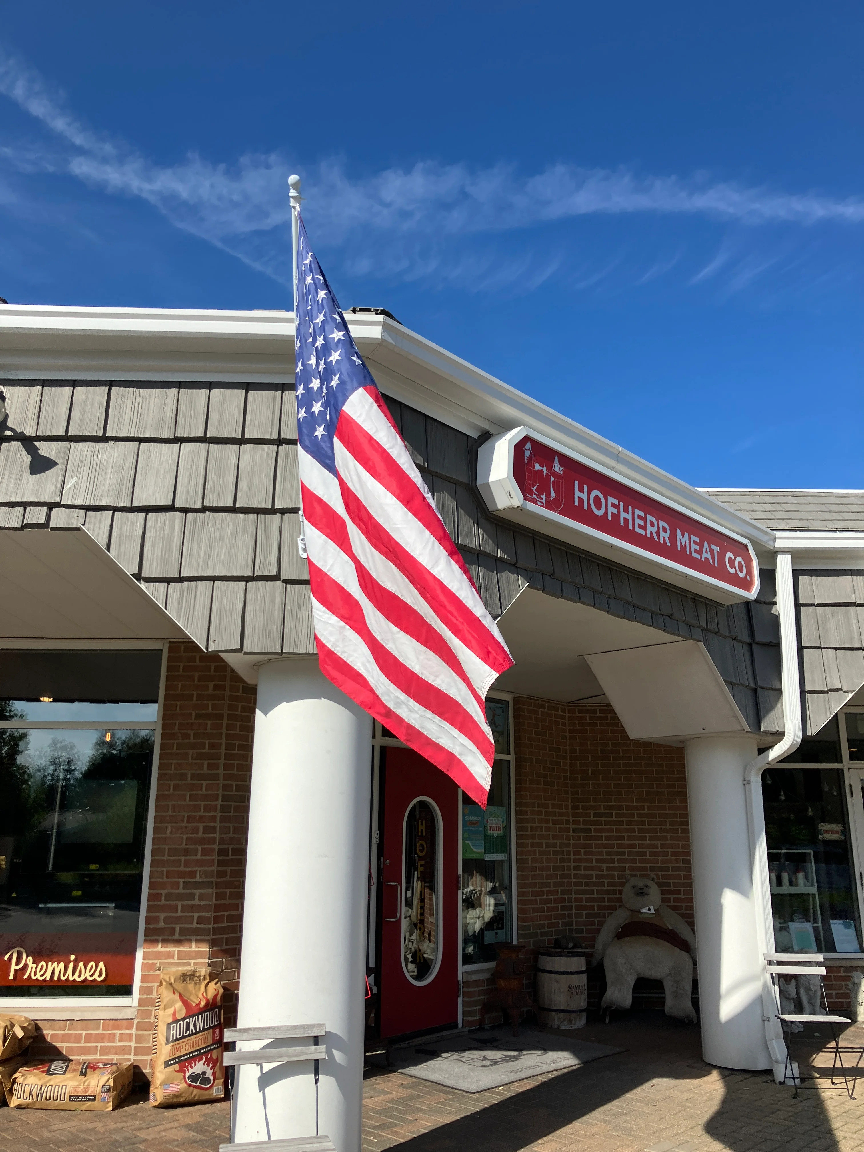 Exterior of Hofherr Meat Co. with American flag and welcoming entrance