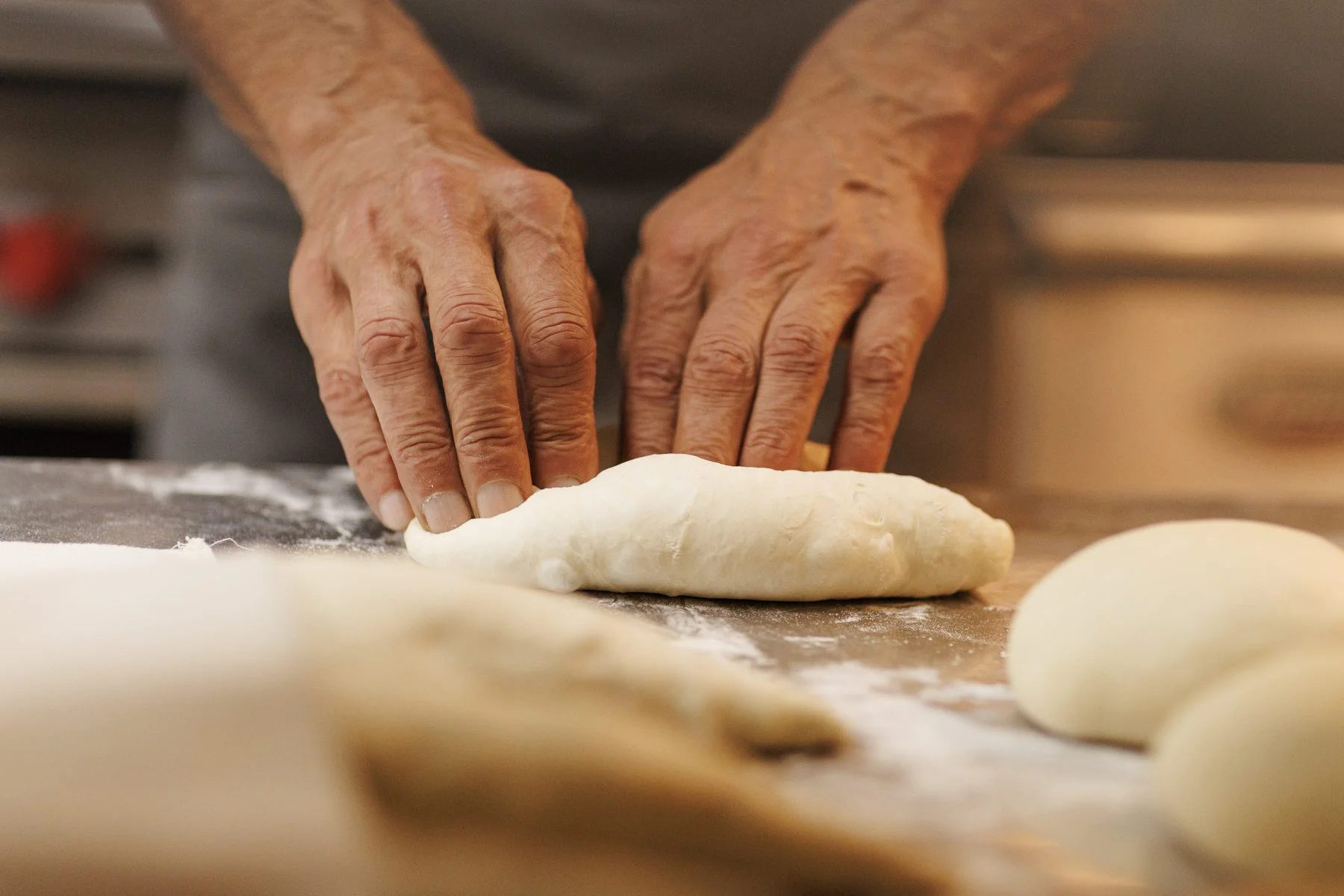 Baker shaping khachapuri dough by hand