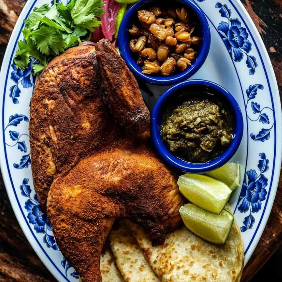 Authentic Mexican pollo asado served with tortillas and salsas