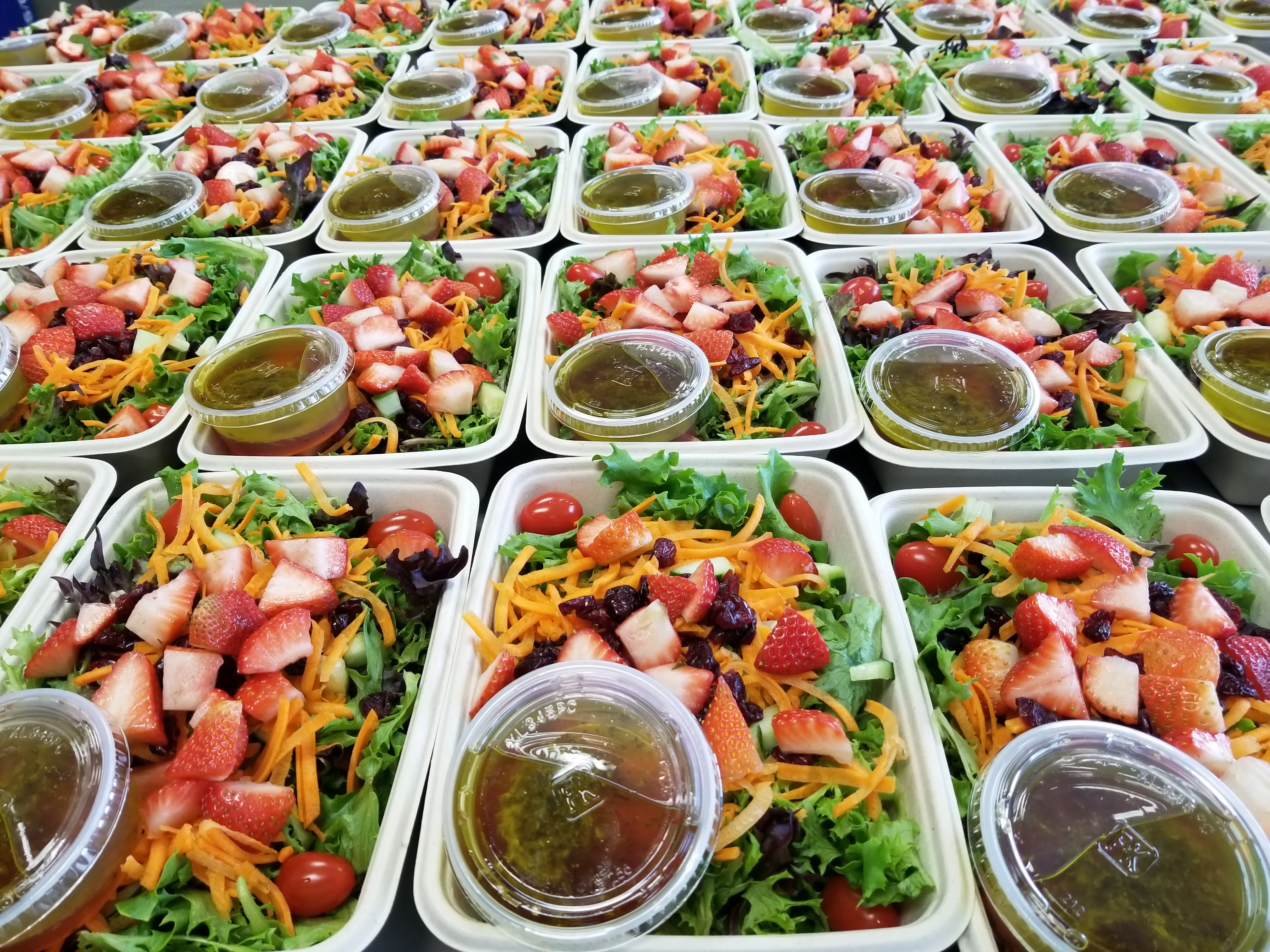 Colorful garden salad with strawberries and dressing